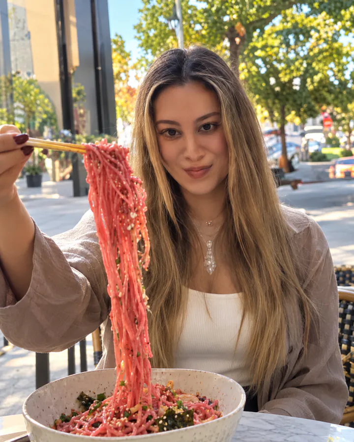 Gülçin im Straßencafé mit pinken Nudeln